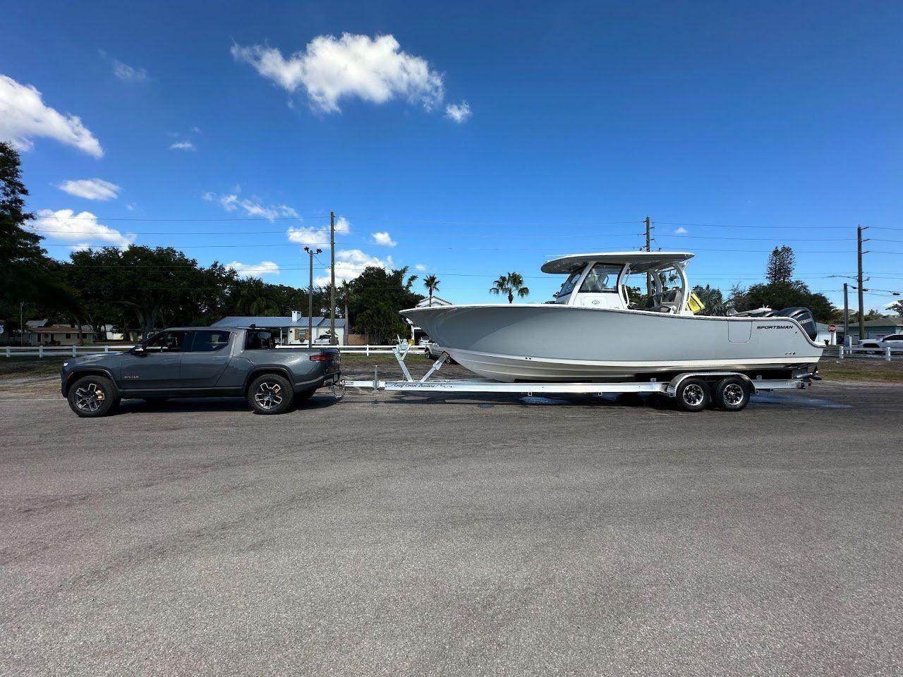 Sportsman 301 Open · Towed by a Rivian electric pickup